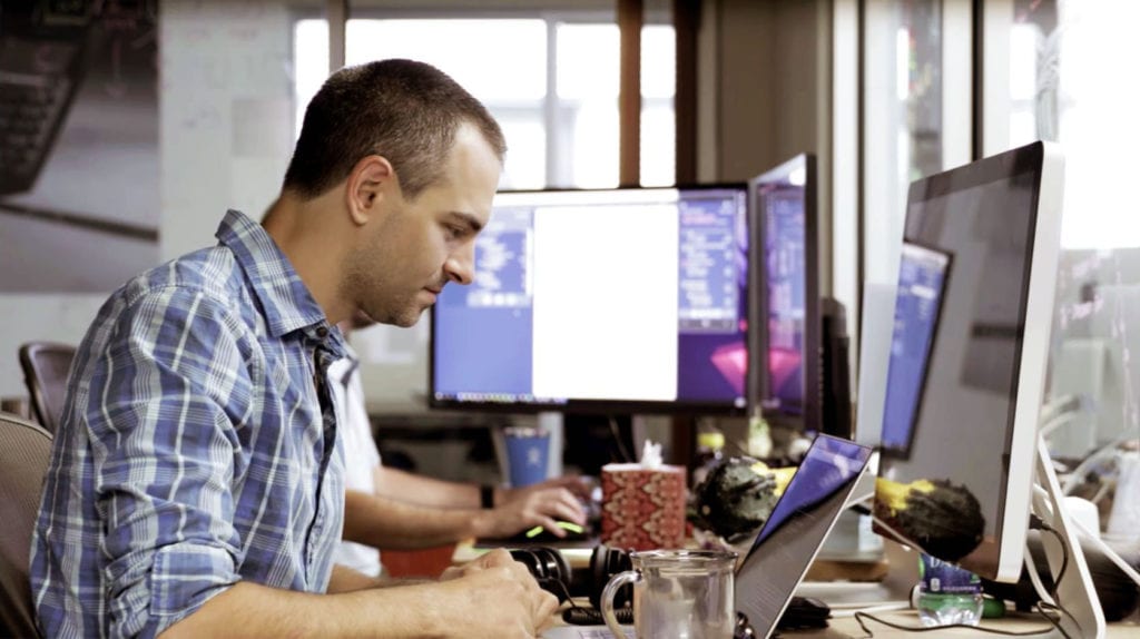 Developer coding at his desk on a laptop