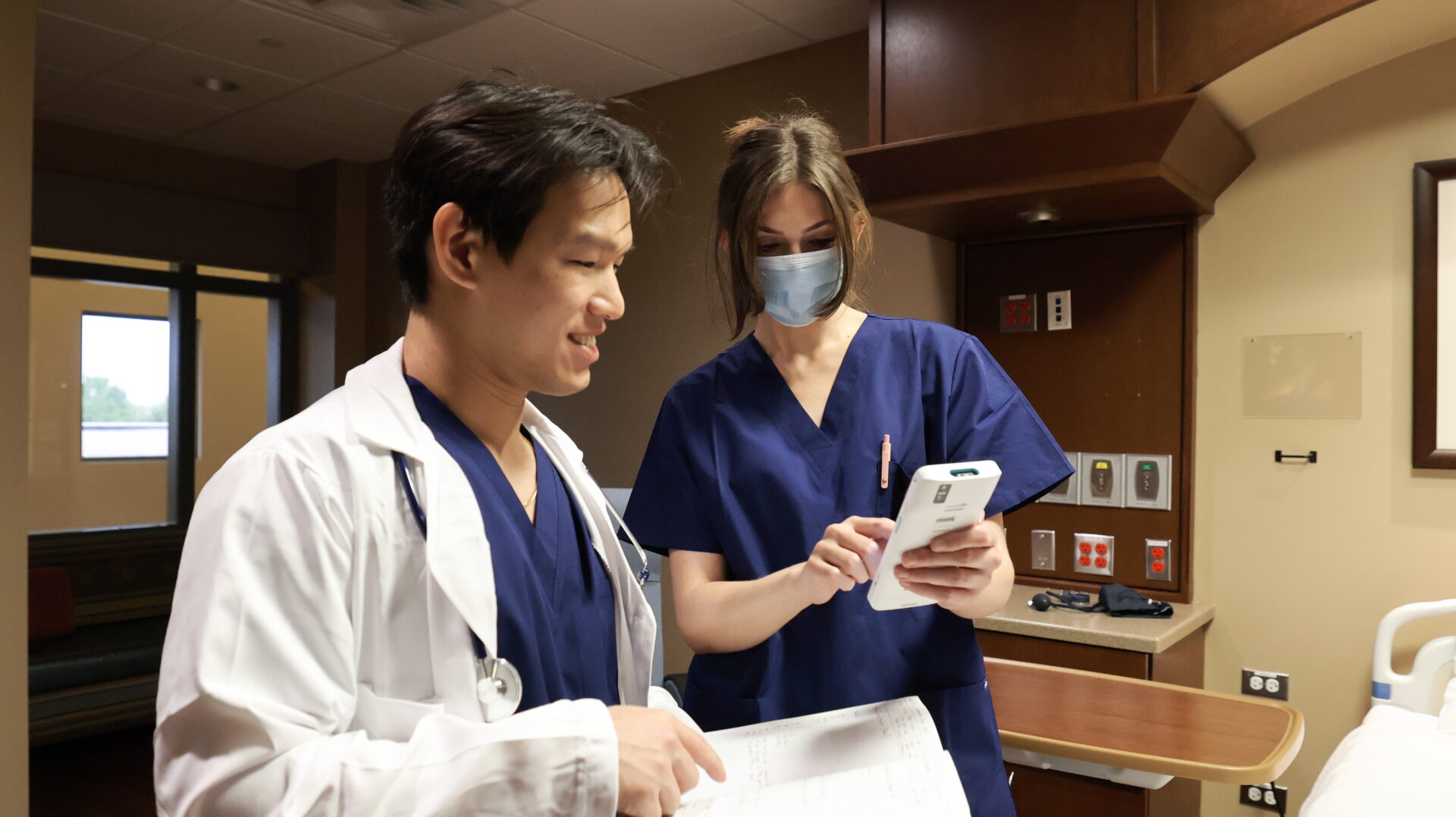 Nurse and doctor looking at an MDM device